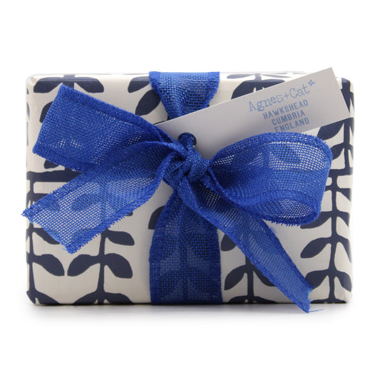 imagen de una caja de regalo ideal para estas fechas, incluye vela aromatica a violetas elaborada con cera de soja natural para una conbustón limpia y duradera